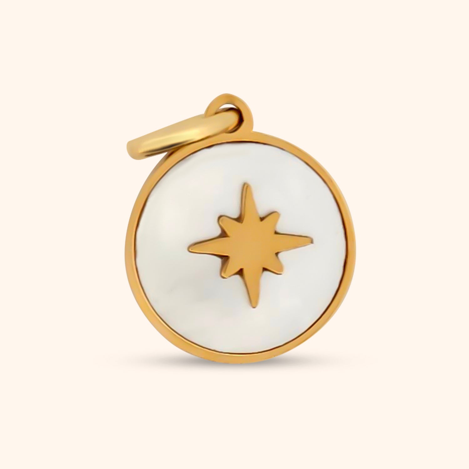 Close-up of the Mariner's Charm, a circular gold charm featuring a mother-of-pearl inlay and a North Star design.